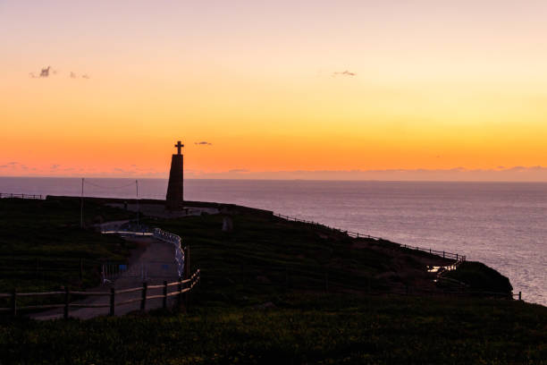 cabo da roca cross monument at sunset. cabo da roca or cape roca is westernmost cape of mainland portugal, continental europe and the eurasian land mass - sintra sunset cross outdoors ストックフォトと画像