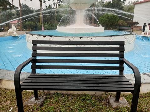The waiting chair in front of a fountain. The empty chair is the symbol of loneliness.