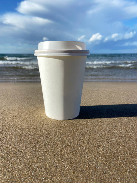 istock Take away coffee cup on beach sand 1939205102