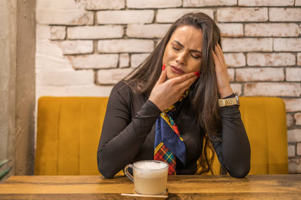 istock A girl has a toothache while sitting in a cafeteria and drinking coffee 1939224432