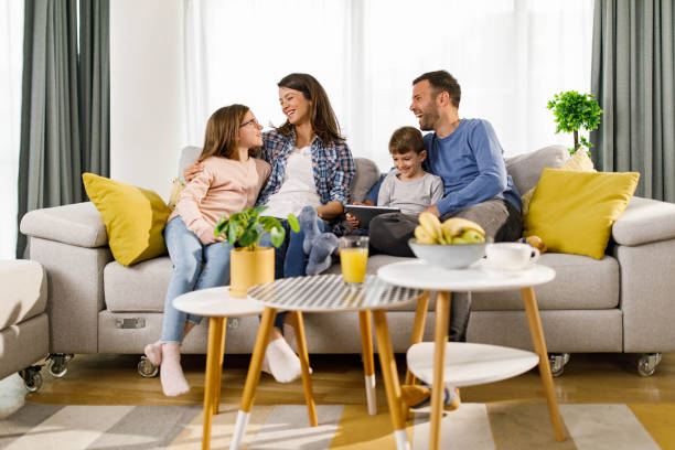 istock Happy family talking while relaxing on sofa at home. 1939267590