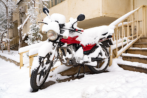 A motorcycle in countryard covered with snow