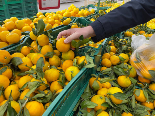 istock A man's hand picking tangerines from a crate at a fruit market. 1939288979