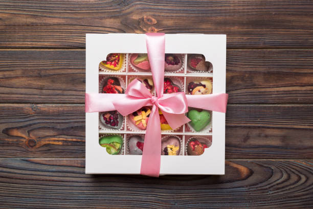 istock Box with sweet chocolate candies on color background, Various candy sweets. Valentines day gift box. Top view flat lay with copy space 1939289539