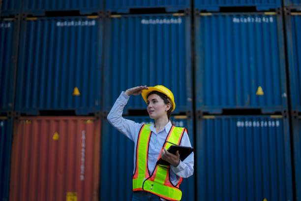 Blue collar workers are working at container warehouse. stock photo