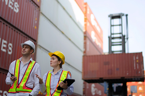 Blue collar workers are working at container warehouse. Blue collar worker and logistics.