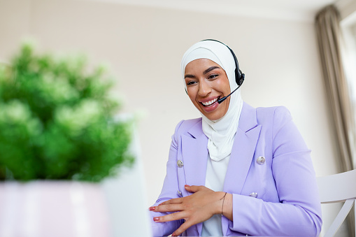 Muslim Business woman with headsets working with computer at office. Customer service assistant working in office. Woman operator working with headsets and laptop at telemarketing customer service. call center