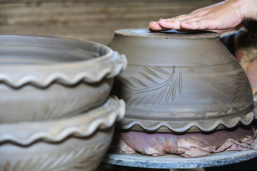 Potter's hands mold clay on a potter's wheel for planting plants. Environmentally friendly products made by human hands,Stay home and work from home