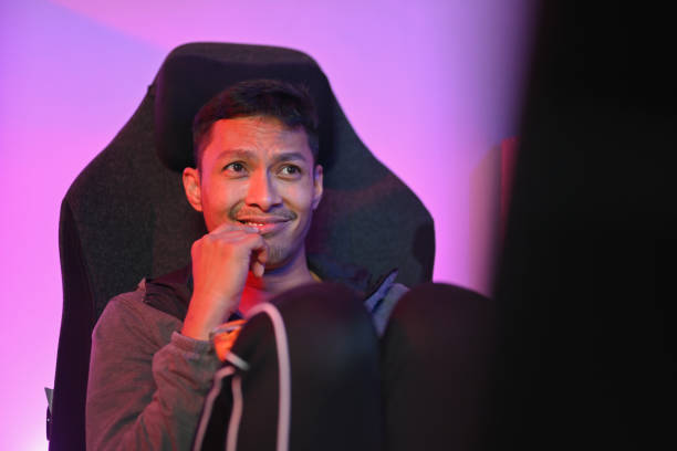 istock Handsome young man eating popcorn and watching a movie on computer at night. 1939332455