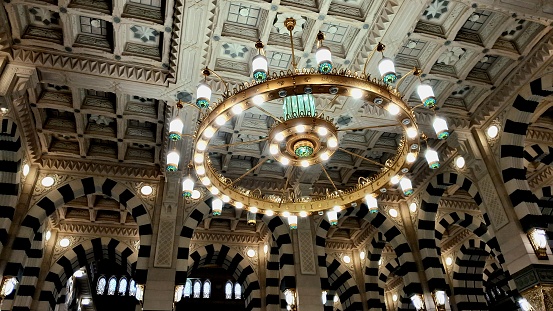A low angle shot of a big luxurious chandelier at the Prophet's Grand Mosque in Medina al-Munawwarah, KSA.