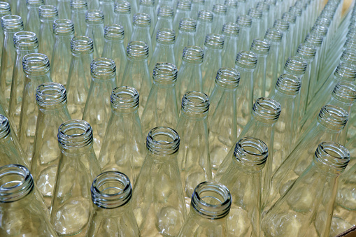 Bottle factory: Glass bottles lined up in large numbers, waiting to be packed.