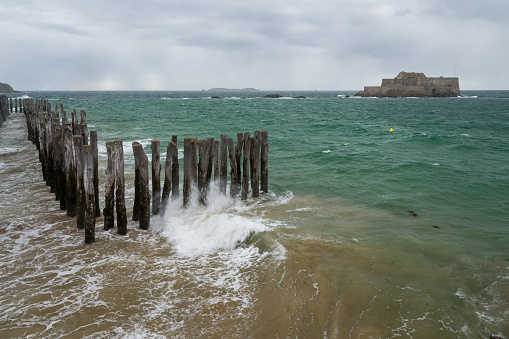 The beach and Fort National during high tide in Saint Malo (Bretagne, France) on a stormy, cloudy day in summer