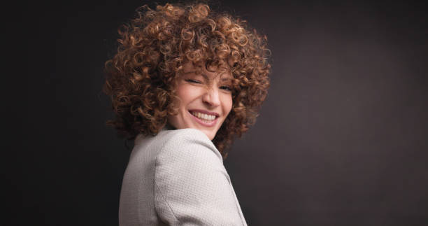 Cheerful female executive in formal suit in studio