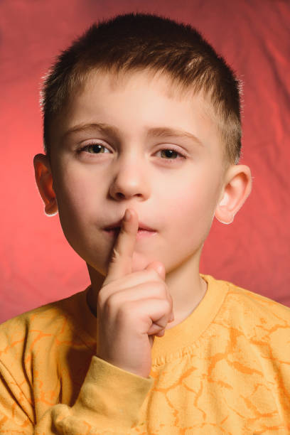 istock The boy with his index finger shows the sign quietly. 1939429486