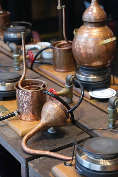 istock Small copper stills and distilling equipment arranged on a decorated table. 1939462465