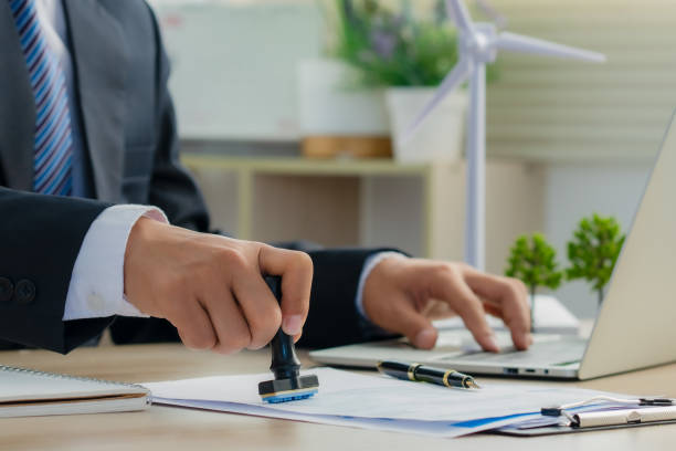 istock Environmental engineer signs approval for green business.Wind turbine models and green renewable energy and sustainability. Ecosystem and Organization Development Cooperation. 1939472721