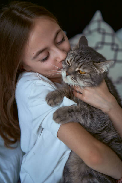 istock girl plays with a cat 1939491281