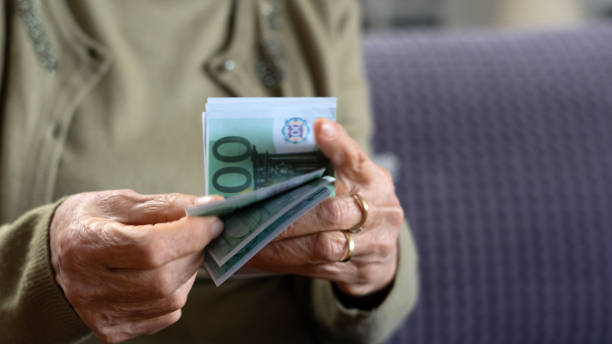 istock old woman holding money 1939498343