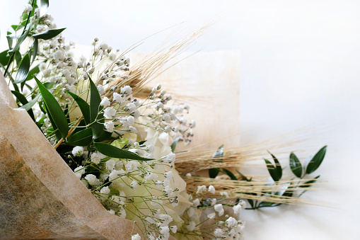 Elegant white roses and babies breath bouquet isolated on white background.Wedding, Valentine's day, birthday, mother's day, anniversary. Fresh flowers. Flat lay. Overhead view. Copy space.