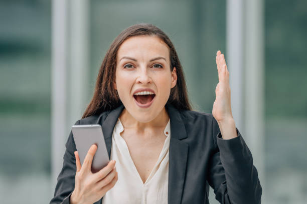 istock business woman with mobile phone and surprised expression 1939500749