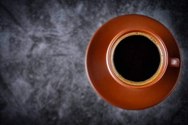 istock Coffee in a brown cup on a table in a cafe on a gray background 1939501140