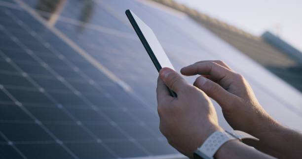 istock Hand, closeup and phone by solar panel at construction site for click, scroll or contact for ecology. Person, smartphone or photovoltaic tech on roof for plan, checklist or sustainability in sunshine 1939503132