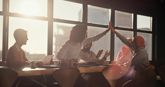 Shot of a diverse group of business people joining their hands in a symbol of unity