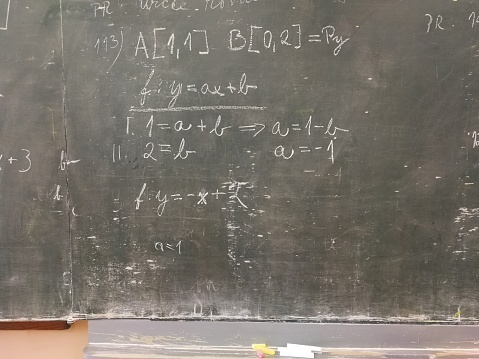 Maths problem at a rather run-down green-board, written in chalk