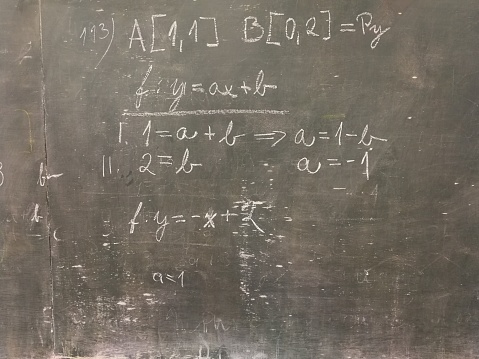 Maths problem at a rather run-down green-board, written in chalk