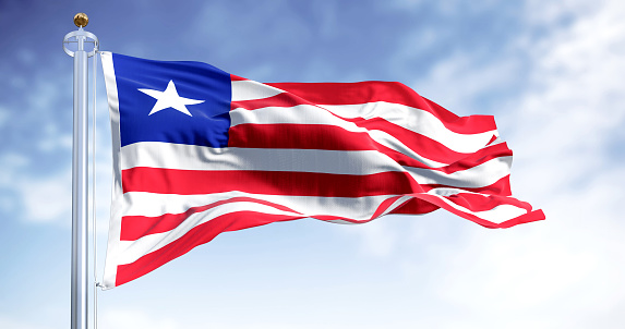 National flag of Liberia waving on a clear day. red and white horizontal stripes that change color and a white star on the blue square in the canton. 3d illustration render. Rippling fabric