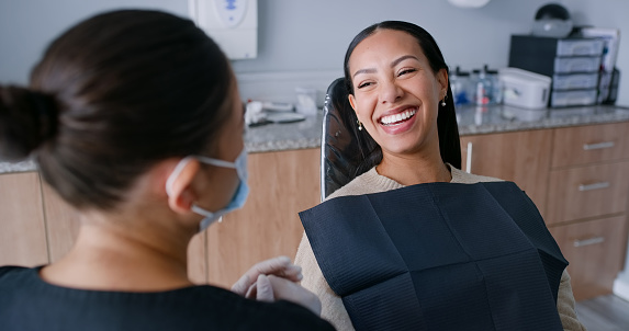 Women, dentist and patient with smile, wellness and oral health, consultation and check mouth with orthodontics. People, medical treatment or professional with dental hygiene, clinic and clean cavity