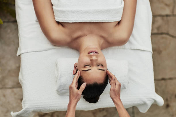 relájese, masaje de cabeza y mujer en el spa para la salud, el bienestar y un tratamiento de belleza de lujo para la calma. paz, cuidado de la piel y mujer joven con rutina de terapia facial natural para el descanso en el salón de belleza. - head massage massaging facial massage beautician fotografías e imágenes de stock