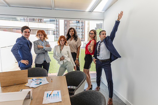 group of multigenerational and multiracial business people, in office, posing jokingly