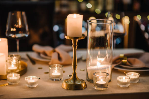 istock Luxury candle light date in restaurant. Bokeh, garlands, bouquet flowers. Romantic dinner setup at night. Table set for couple, Valentine's Day evening, burning candles for surprise marriage proposal. 1939523813
