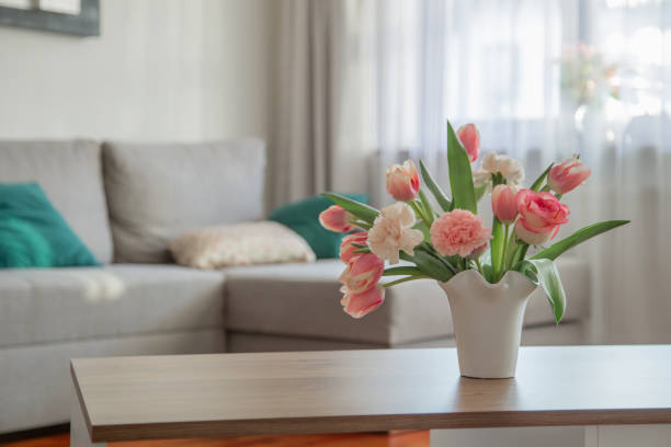 pink spring flowers in white ceramic vase in modern home interior