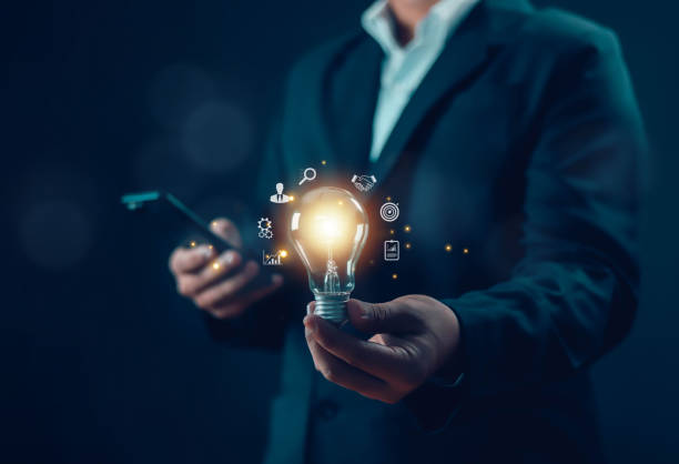 istock businessman holding a light bulb Innovative and inspirational concept, idea, brain, light bulb, light, understanding, digital, light bulb, idea, research and network connection on virtual interface ba 1939538565