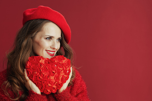 Happy Valentine. smiling stylish woman in red sweater and beret with red heart.