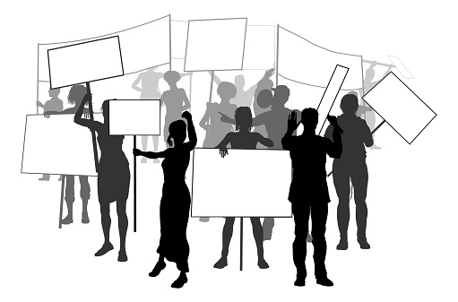 A silhouette crowd or group of people demonstrators at a protest, rally or strike with signs