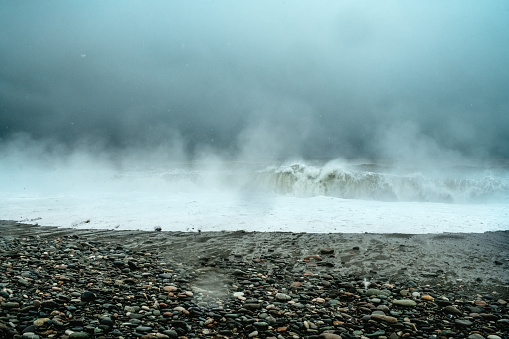 Fog and snow over the sea in unusual cold weather. Global climate change and ecological problems concept.