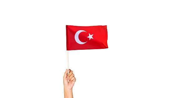 Turkish flag. Hand holding waving the national flag of Turkey against a white background.