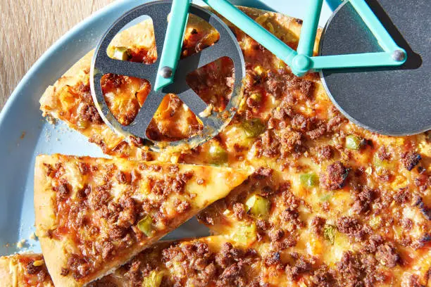 Kitchen pizza cutter like a bicycle on wooden table