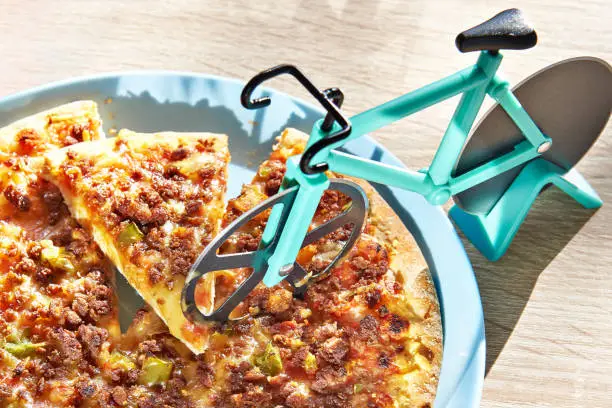 Kitchen pizza cutter like a bicycle on wooden table