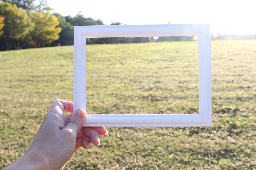 Hand holding blank wooden picture frame