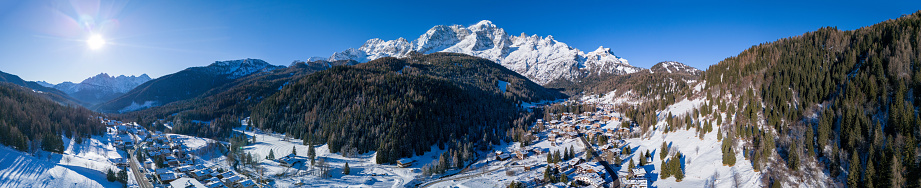 An aerial view of snowy Val di Zoldo, Italy with charming houses and beautiful nature