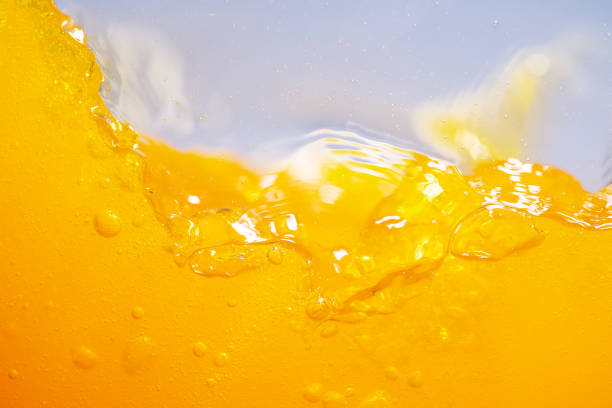 Close up bright orange juice splash texture for health and nature waves, Beautiful waves curve and little bubbles smooth for garphic design and background