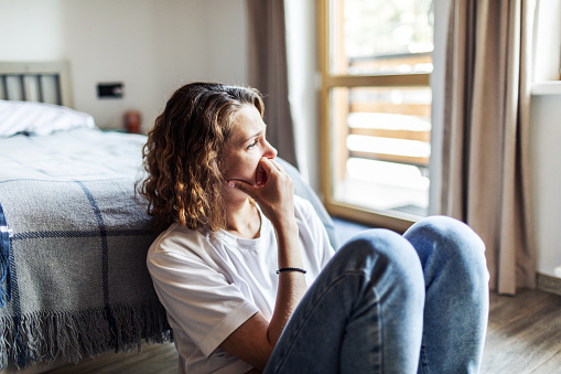 Depressed Woman Sitting by Window