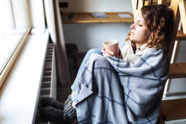 Young adult woman with flu drinking tea
