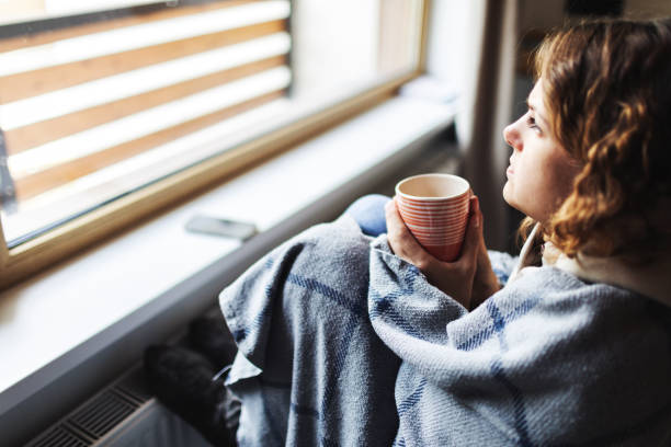 istock Young adult woman with flu drinking tea 1939655010