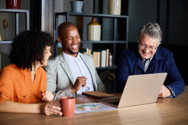 istock Diverse businesspeople laughing over a laptop at an office table 1939656065