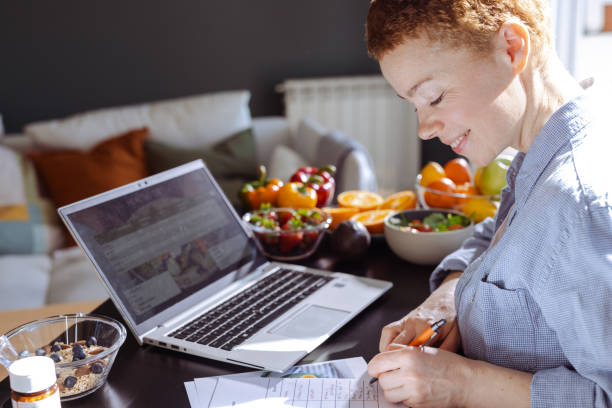 istock Female nutritionist makes a diet plan for a client and using laptop 1939673463